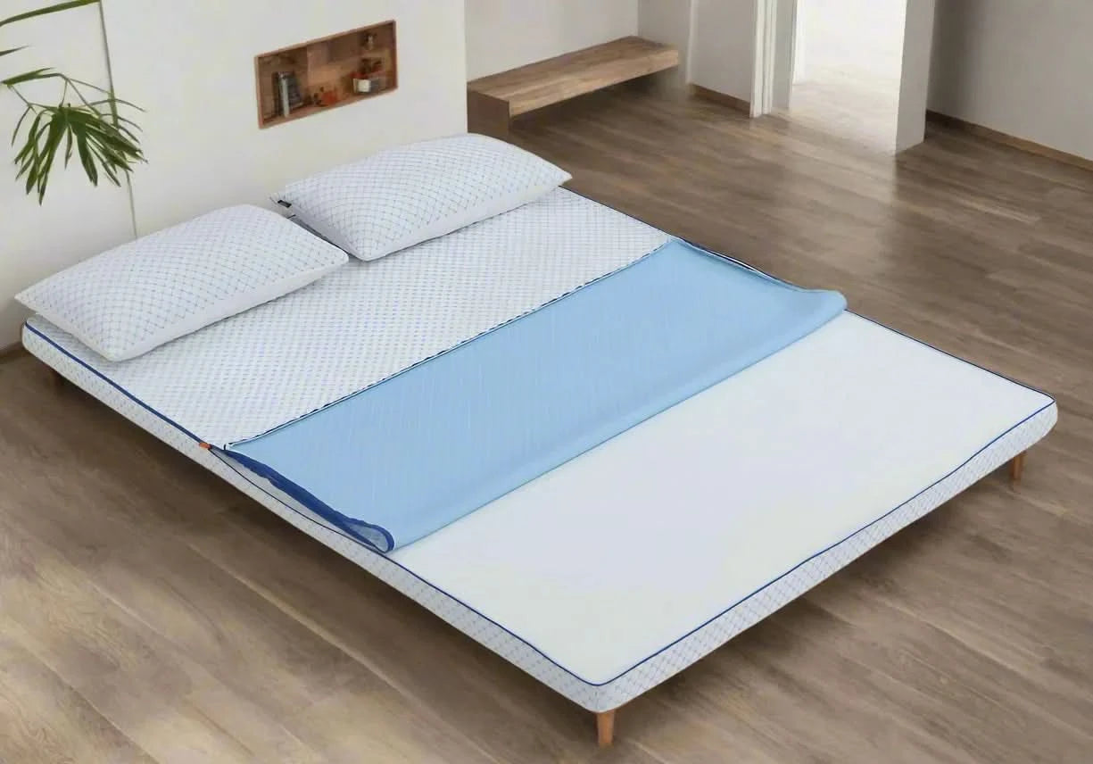 White Dreams to Go Kool Mattress Topper with blue cooling layer partially folded back, on a wooden bed frame with two pillows.