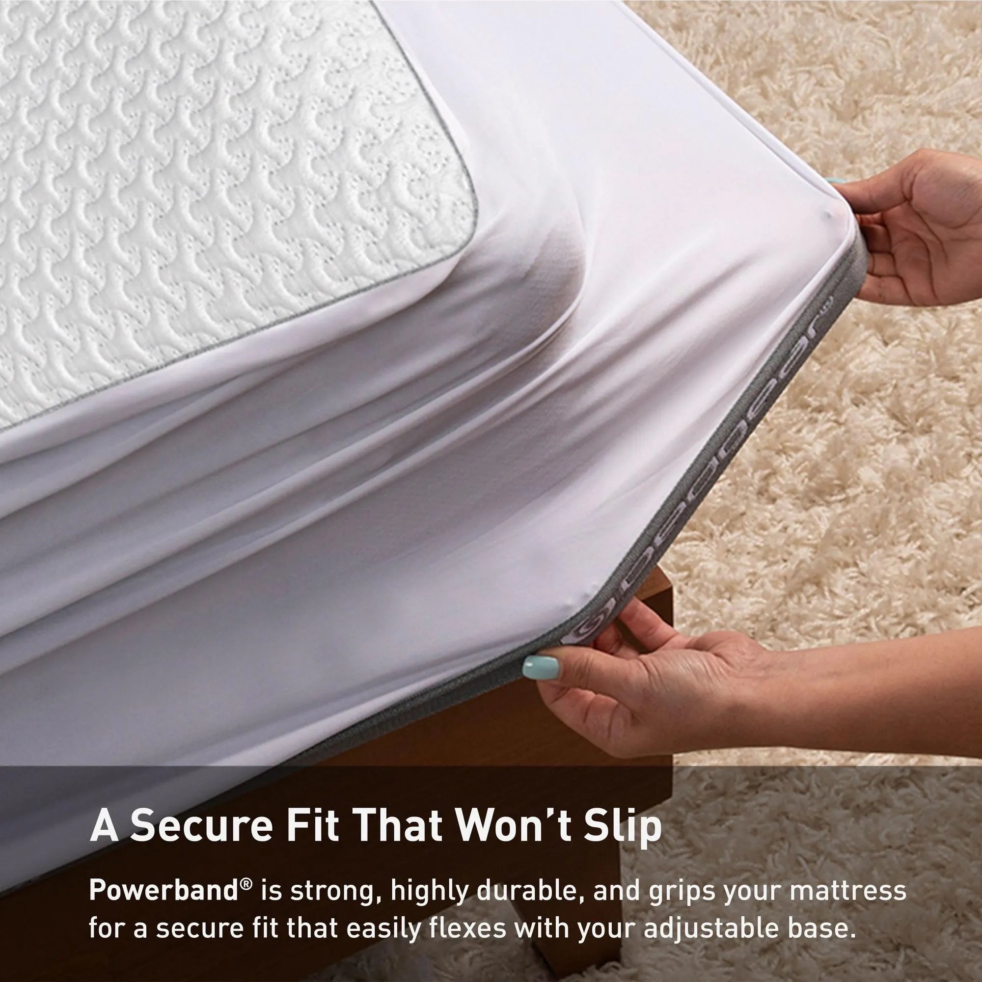 White Bedgear Ver-Tex™ mattress protector being stretched over a mattress, showing its cooling fabric and Powerband®.